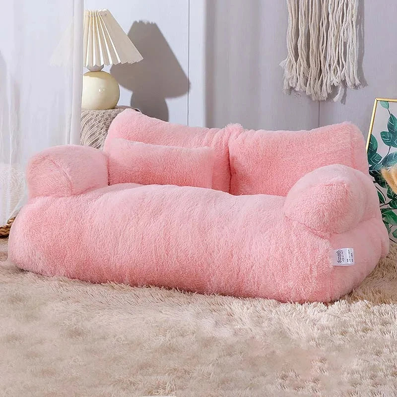 Pink fluffy pet bed on a carpeted floor with a lamp and decorative items in the background.