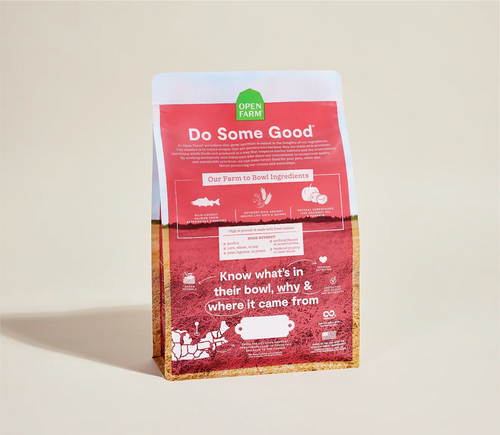 Red bag of Open Farm dog food with a green label on a beige background