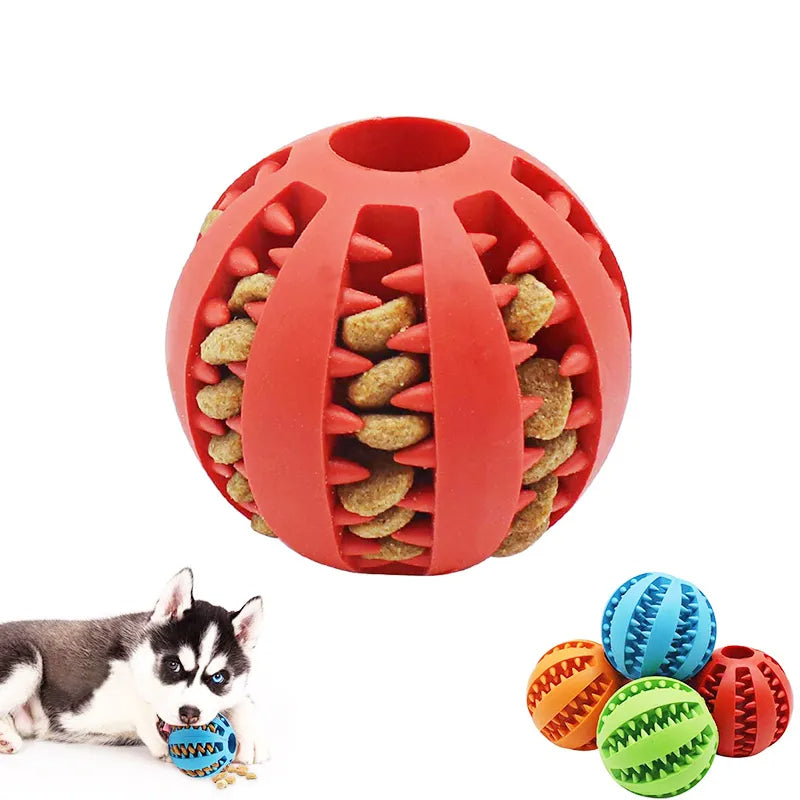 Red dog toy ball with treats inside, shown with a dog and additional colorful balls on a white background.