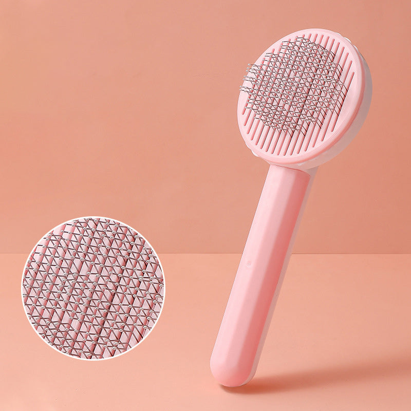 Pink pet grooming brush with close-up detail on a pink background