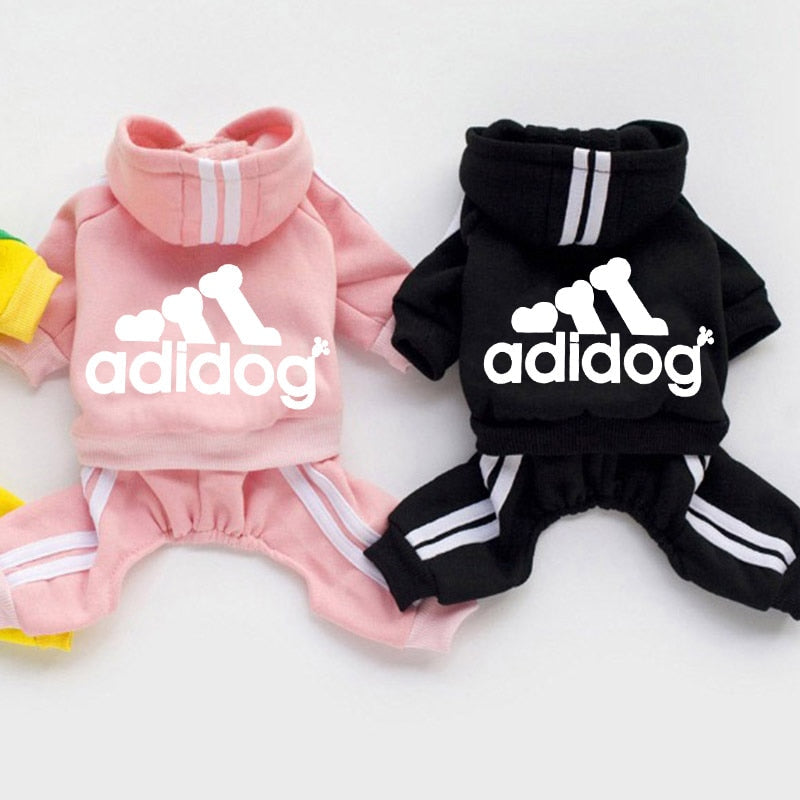 Pink and black dog outfits with 'adidog' branding on a white background