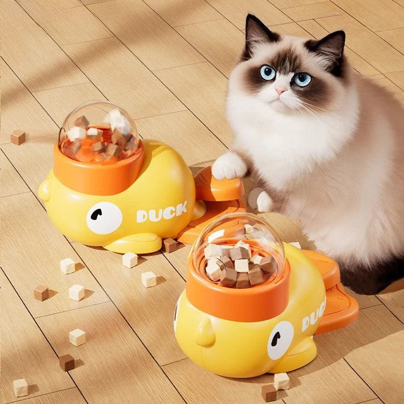 Cat playing with a yellow duck-shaped toy on a wooden floor