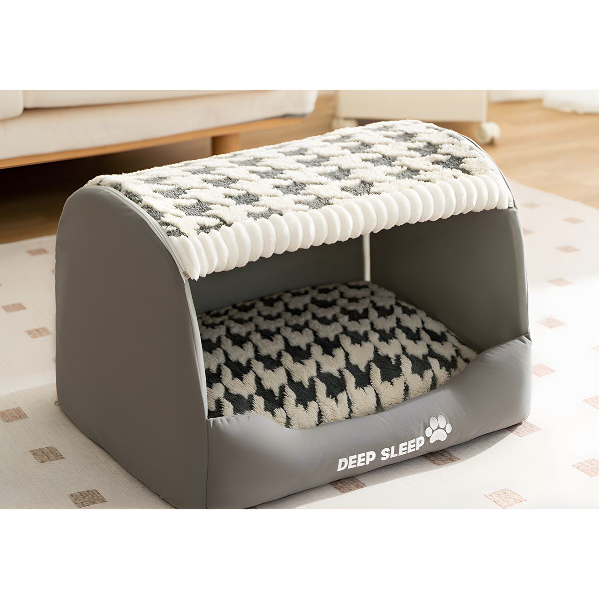 A gray pet bed with a houndstooth-patterned cushion and matching patterned roof, shown in a home setting on a patterned rug.